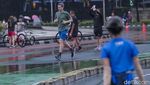 Salut! Warga Berolahraga saat Rintik Hujan Mengguyur Jakarta