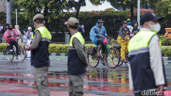 Salut! Warga Berolahrga saat Rintik Hujan Mengguyur Jakarta Hujan mengguyur Jakarta sejak malam hari hingga pagi ini. Meski demikian warga tetap berolahraga di area car free day (CFD) Bundaran HI Jakarta, Minggu (12/2/2023).