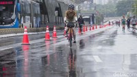 Sejumlah warga tengah berolahraga di tengah rintik hujan pada Hari Bebas Kendaraan Bermotor (HBKB) atau car free day (CFD) di kawasan Bundaran Hotel Indonesia, Jakarta, Minggu (12/2/2023).