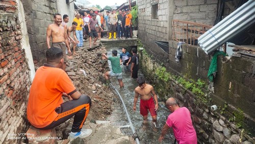 Warga di Kelurahan Kampung Anyar, Buleleng, Bali, memperbaiki tanggul Kali Mumbul yang jebol tergerus banjir, Minggu (12/2/2023). (Foto: Ist.)