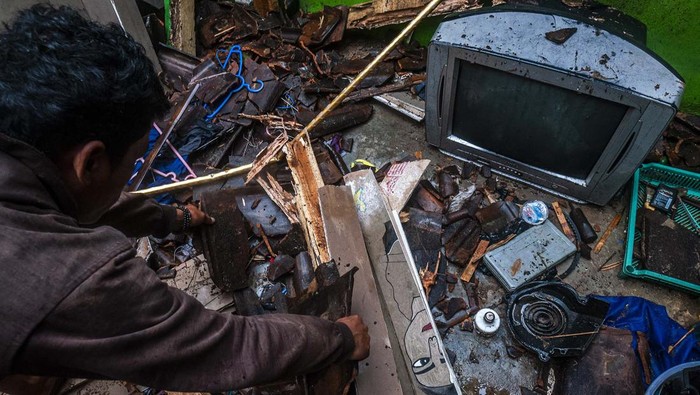 DAMPAK HUJAN DERAS DAN ANGIN KENCANG DI LEBAK Pemilik rumah membersihkan puing-puing atap yang ambruk di Desa Pasir Tanjung, Lebak, Banten, Minggu (12/2/2023). Hujan deras disertai angin kencang yang terjadi di daerah tersebut sejak pagi hari mengakibatkan sejumlah rumah mengalami kerusakan. ANTARA FOTO/Muhammad Bagus Khoirunas/nz