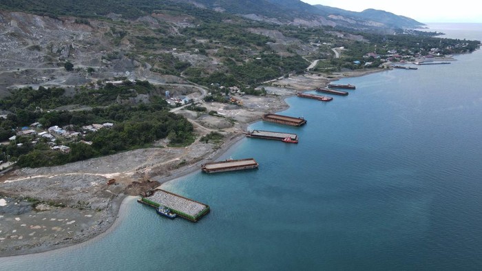 Foto udara sejumlah kapal tongkang mengangkut material batu pecah di Kawasan Tambang Galian C di Palu, Sulawesi Tengah, Minggu (12/2/2023). Hasil tambang tersebut dipasarkan ke wilayah Kalimantan hingga Papua dan Provinsi Sulawesi Tengah menjadi salah satu kawasan strategis penyangga Ibu Kota Negara (IKN) Nusantara di Kalimantan Timur yang siap menyuplai kebutuhan material seperti pasir, kerikil dan batu guna pembangunan infrastruktrur IKN. ANTARA FOTO/Mohamad Hamzah/nz.
