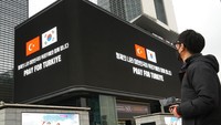 Seorang pria melihat papan reklame yang berada di Seoul, Korea Selatan, Senin (13/2/2023).