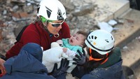 Anggota tim penyelamat mengevakuasi bayi bernama Ayse Vera dari reruntuhan bangunan akibat gempa setelah tertimbun selama 29 jam. Aytug Can Sencar/Getty Images