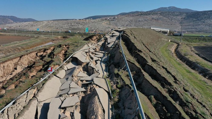 Penampakan Jalanan di Turki Rusak Berat Akibat Gempa Dahsyat KAHRAMANMARAS, TURKIYE - FEBRUARY 12: An aerial view of the damaged road, part of which passes over Adiyaman, Sanliurfa and Gaziantep highway, connecting Cocelli village and Evri neighborhood after 7.7 and 7.6 magnitude earthquakes hit multiple provinces of Turkiye including Kahramanmaras on February12, 2023. Early Monday morning, a strong 7.7 earthquake, centered in the Pazarcik district, jolted Kahramanmaras and strongly shook several provinces, including Gaziantep, Sanliurfa, Diyarbakir, Adana, Adiyaman, Malatya, Osmaniye, Hatay, and Kilis. Later, at 13.24 p.m. (1024GMT), a 7.6 magnitude quake centered in Kahramanmaras' Elbistan district struck the region. Turkiye declared 7 days of national mourning after deadly earthquakes in southern provinces. (Photo by Halife Yalcinkaya/Anadolu Agency via Getty Images)