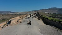 Gempa berkekuatan M 7,8 itu membuat jalan yang menghubungkan desa Cocelli dan lingkungan Evri rusak berat. (Halife Yalcinkaya/Anadolu Agency/Getty Images)  
