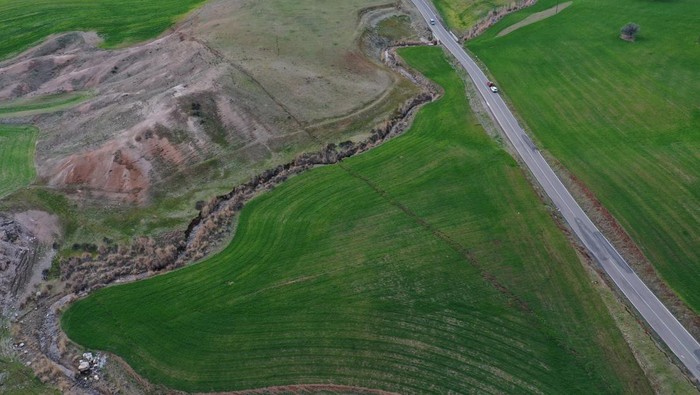 Penampakan Retakan Tanah Akibat Gempa Dahsyat di Turki Aerial view shows cracks in the ground in the aftermath of a deadly earthquake, near the Tevekkeli village in Kahramanmaras, Turkey February 10, 2023. REUTERS/Issam Abdallah