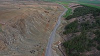 Retakan tanah akibat gempa dahsyat itu tampak membelah ladang, jalan, sungai, dan lereng bukit.  
