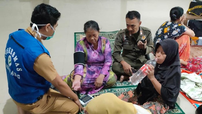 Petugas kesehatan memeriksa kesehatan pengungsi korban banjir di Makassar.