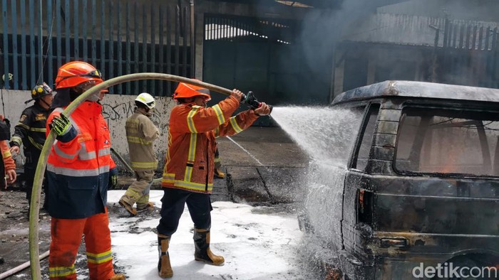 Petugas melakukan pemadaman terhadap mobil carry yang terbakar di Jl Ibrahim Ajie, Kota Bandung, Senin (13/2/20223)