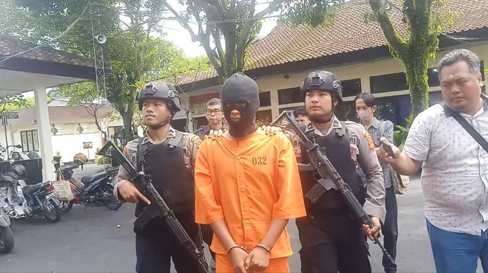 Tersangka perampokan yang melakukan percobaan pemerkosaan digiring oleh kepolisian menuju Aula Polres Jembrana, Senin (13/2/2023). (Foto: I Putu Adi Budiastrawan/detikBali)