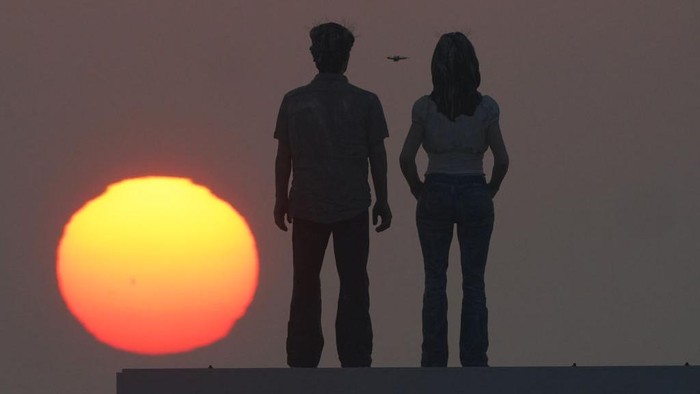 The sunrises through the sea mist over the sculpture 