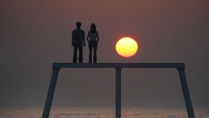 1247100373 The sunrises through the sea mist over the sculpture