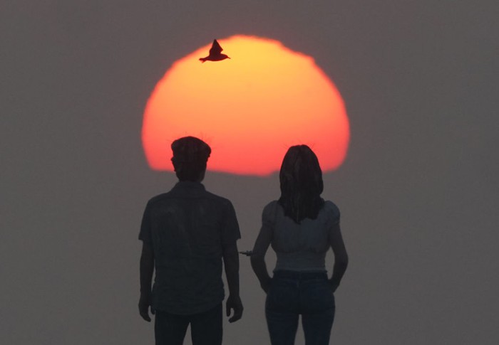 The sunrises through the sea mist over the sculpture 