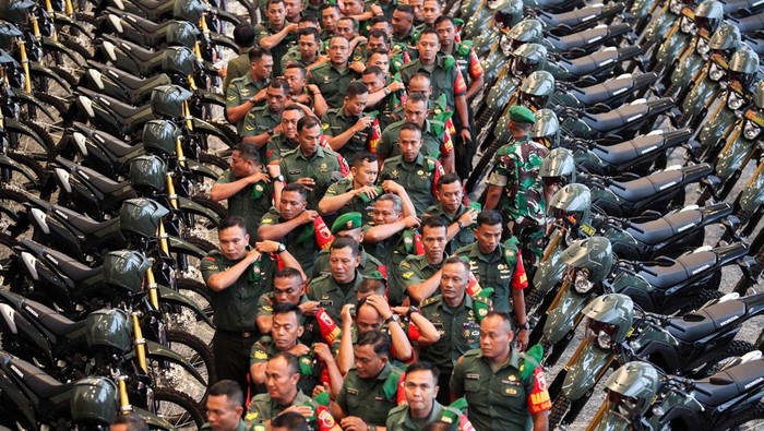 Sejumlah personel TNI Angkatan Darat yang bertugas sebagai Babinsa berjalan di dekat sepeda motor bantuan di Grand City Mall, Surabaya, Jawa Timur, Senin (13/2/2023).Kementerian Pertahanan memberi bantuan kendaraan operasional untuk prajurit TNI Angkatan Darat yang bertugas sebagai Babinsa sebanyak 100 unit sepeda motor untuk memperlancar tugas-tugasnya. ANTARA FOTO/Didik Suhartono/rwa.