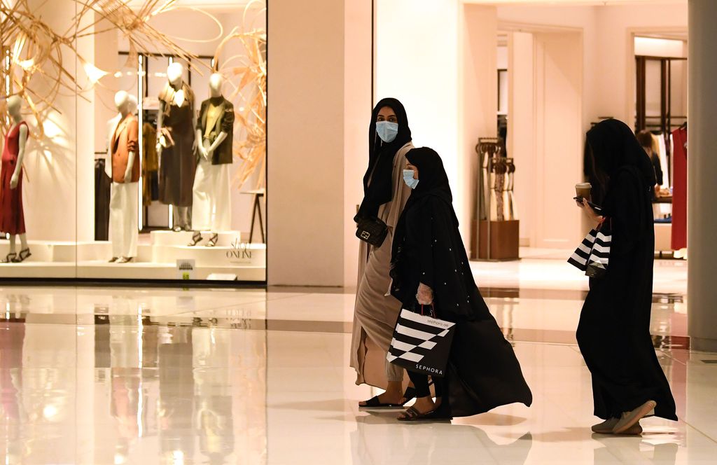 Women wearing masks for protection against the coronavirus, walk in the Mall of Dubai on April 28, 2020, after the shopping centre was reopened as part of moves in the Gulf emirate to ease lockdown restrictions imposed last month to prevent the spread of the COVID-19 illness. (Photo by Karim SAHIB / AFP) (Photo by KARIM SAHIB/AFP via Getty Images)
