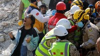 Seorang dari seorang wanita Turki Saadet Sendag bereaksi ketika ibunya diselamatkan setelah 177 jam, di lokasi bangunan yang runtuh setelah gempa mematikan di Hatay, Turki 13 Februari 2023.