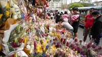 Orang-orang berbelanja di pasar bunga di sepanjang jalan ramai di Manila. Harga bunga naik karena tingginya permintaan sehari sebelum Hari Valentine.  