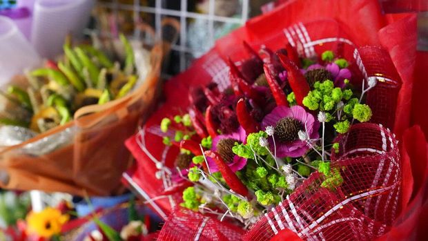 People buy from a flower market along a busy road in Manila, Philippines on Monday, Feb. 13, 2023. Prices of flowers have increased due to the high demand a day before Valentines Day. (AP Photo/Aaron Favila)