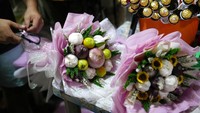 Seorang pekerja membuat karangan bunga yang terbilang unik. Karangan atau buket itu terbuat dari bawang merah, tomat, dan bawang putih.