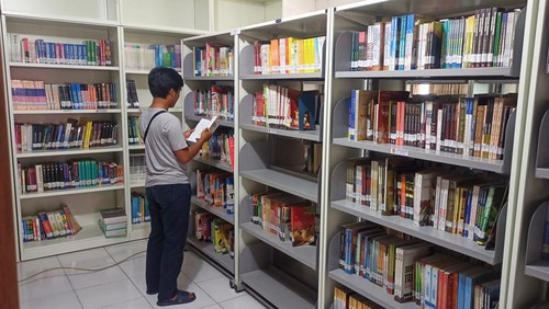 Salah seorang pengunjung saat memilih buku untuk dibaca di Perpustakaan Daerah Kabupaten Karangasem Senin (14/2/2023). (foto : I Wayan Selamat Juniasa)