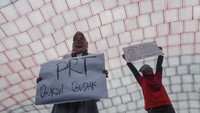 Sejumlah aktivis membawa poster di bawah kain lap raksasa yang dibentangkan dalam aksi damai memperingati Hari Pekerja Rumah Tangga di depan kompleks Parlemen, Senayan, Jakarta.  