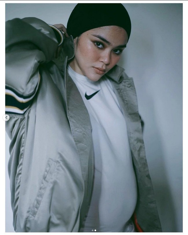 Memperlihatkan baby bump alias perut hamilnya, Sivia Azizah mengunggah foto OOTD dengan style hijab boyish. Dia memadukan hijab hitam yang diikat rapi ke belakang, kaus dan jaket oversized. Foto: Instagram @siviazizah.