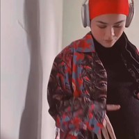 Dalam unggahannya Sivia memperlihatkan momennya mengelus perutnya yang semakin membesar.  Sivia bergaya boyish memakai turban oranye, kemeja oversized dan headphone di kepalanya. Foto: Dok. Instagram @siviazizah.