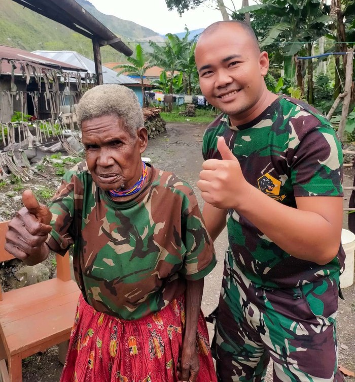 Satgas Yonif Raider 142/KJ melalui Pos Kurima memberikan pangkas rambut kepada seorang mama Papua bernama Mama Martina Wentipo. Ini momen saat anggota TNI memetong rambut Martina.