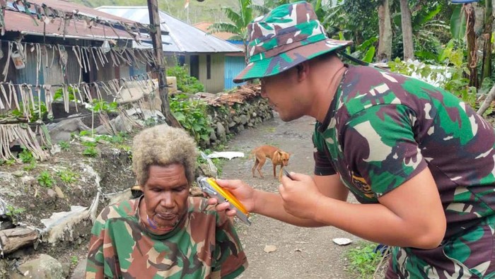 Momen Mama Papua Dipotong Rambutnya oleh Anggota TNI Satgas Yonif Raider 142/KJ melalui Pos Kurima memberikan pangkas rambut kepada seorang mama Papua bernama Mama Martina Wentipo. Ini momen saat anggota TNI memetong rambut Martina.