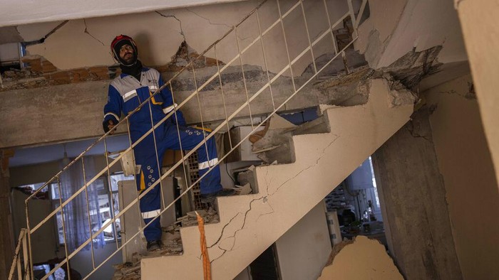 Mehmet Gurkan, a member of the Turkish animal rights group HAYTAP, rescues a dog that was trapped for seven days inside a house affected by the earthquake in Antakya, southeastern Turkey, on Sunday, Feb. 12, 2023. (AP Photo/Bernat Armangue)