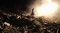 Tim SAR harus menembus debu puing bangunan demi untuk mencari korban gempa. Umit Turhan Coskun/NurPhoto via Getty Images.