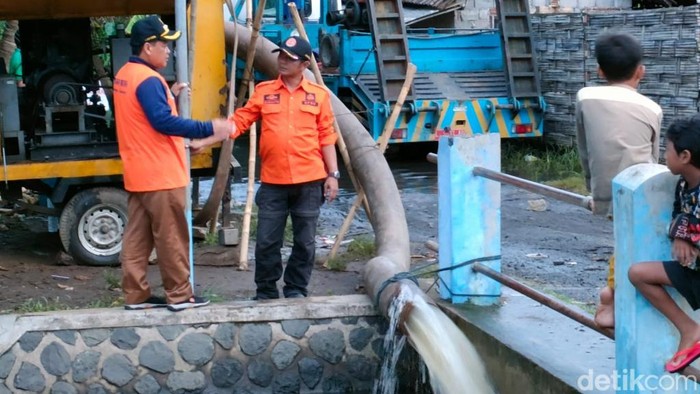 Petugas memompa air banjir di Rejoso Pasuruan yang belum surut