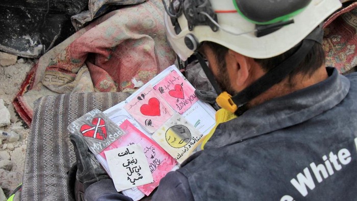 Potret Pilu Buku Harian Anak-anak Korban Gempa di Suriah A White Helmets member looks at a notebook found at a damaged building, in the aftermath of an earthquake, in rebel-held town of Jandaris, Syria, February 10, 2023. White Helmets/Handout via REUTERS THIS IMAGE HAS BEEN SUPPLIED BY A THIRD PARTY. NO RESALES. NO ARCHIVES. MANDATORY CREDIT. TPX IMAGES OF THE DAY