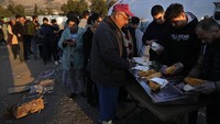 Para korban gempa mengantre untuk mendapatkan bantuan makanan di tenda pengungsian di Iskenderun, Turki, Selasa (14/2/2023).