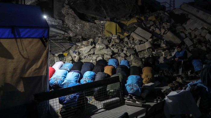 Warga Turki tetap menunaikan ibadah salat meski masjid hingga rumah ambruk akibat gempa. Salat dilakukan di sekitar reruntuhan bangunan.
