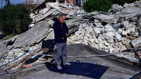 Seorang warga menunaikan ibadah salat di sekitar reruntuhan masjid di Hatay, Turki, Sabtu (11/2/2023) lalu. Yasin Akgul/AFP via Getty Images.