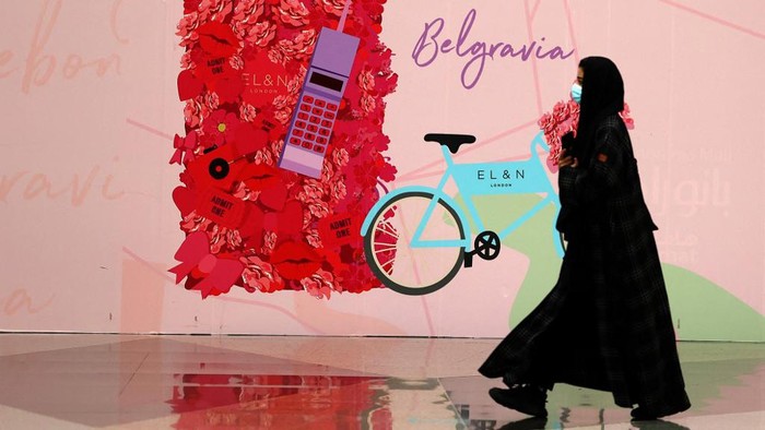 A woman walks past shop advertisements ahead of Valentines day, in Panorama mall in the Saudi capital Riyadh, on February 9, 2022. - Red clothing and underwear are displayed in Saudi shops, but the increasingly popular Valentines Day promotions are missing one thing: the festivals name. (Photo by AFP)