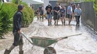Warga membersihkan lumpur akibat banjir di Napier, Selandia Baru, Rabu (15/2/2023). Banjir tersebut disebabkan karena Topan Gabrielle yang menerjang negara itu. Getty Images/Kerry Marshall