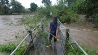 Sungai Dengkeng yang meluap membuat tumpukan sampah dan bambu menyumbat sebuah jembatan. Akibatnya akses jalan warga terganggu.  