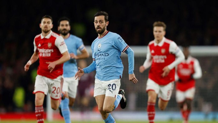 Manchester Citys Portuguese midfielder Bernardo Silva (C) runs with the ball during the English Premier League football match between Arsenal and Manchester City at the Emirates Stadium in London on February 15, 2023. - - RESTRICTED TO EDITORIAL USE. No use with unauthorized audio, video, data, fixture lists, club/league logos or live services. Online in-match use limited to 120 images. An additional 40 images may be used in extra time. No video emulation. Social media in-match use limited to 120 images. An additional 40 images may be used in extra time. No use in betting publications, games or single club/league/player publications. (Photo by Ian Kington / IKIMAGES / AFP) / RESTRICTED TO EDITORIAL USE. No use with unauthorized audio, video, data, fixture lists, club/league logos or live services. Online in-match use limited to 120 images. An additional 40 images may be used in extra time. No video emulation. Social media in-match use limited to 120 images. An additional 40 images may be used in extra time. No use in betting publications, games or single club/league/player publications. / RESTRICTED TO EDITORIAL USE. No use with unauthorized audio, video, data, fixture lists, club/league logos or live services. Online in-match use limited to 120 images. An additional 40 images may be used in extra time. No video emulation. Social media in-match use limited to 120 images. An additional 40 images may be used in extra time. No use in betting publications, games or single club/league/player publications. (Photo by IAN KINGTON/IKIMAGES/AFP via Getty Images)