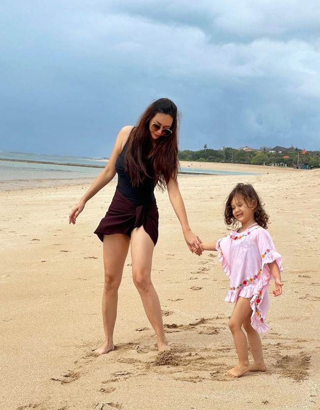 Bermain bersama di pantai, Aura Kasih dan putrinya tampak kompak. Sama-sama cantik, penampilan keduanya pun banjir pujian netizen. Foto: Instagram/@aurakasih