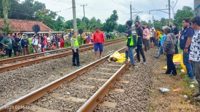 Evakuasi pemotor yang tertabrak kereta di perlintasan sebidang tanpa palang pintu di Parung Panjang, Kabupaten Bogor.