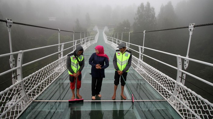 Gubernur Jawa Timur Khofifah Indar Parawansa (kanan) berjalan di atas jembatan gantung kaca di Seruni Point Kawasan Strategis Pariwisata Nasional (KSPN) Bromo-Tengger-Semeru, Probolinggo, Jawa Timur, Rabu (15/2/2023). Kementerian PUPR membangun jembatan sepanjang 120 meter yang dapat menampung 100 orang tersebut bertujuan untuk menunjang perkembangan pariwisata dan perekonomian masyarakat di kawasan Bromo. ANTARA FOTO/Umarul Faruq/tom.