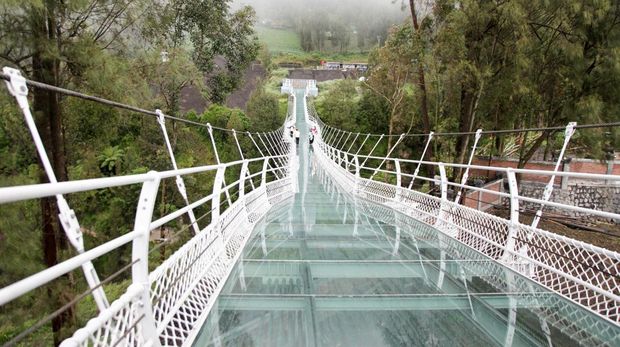 Gubernur Jawa Timur Khofifah Indar Parawansa (kanan) berjalan di atas jembatan gantung kaca di Seruni Point Kawasan Strategis Pariwisata Nasional (KSPN) Bromo-Tengger-Semeru, Probolinggo, Jawa Timur, Rabu (15/2/2023). Kementerian PUPR membangun jembatan sepanjang 120 meter yang dapat menampung 100 orang tersebut bertujuan untuk menunjang perkembangan pariwisata dan perekonomian masyarakat di kawasan Bromo. ANTARA FOTO/Umarul Faruq/tom.