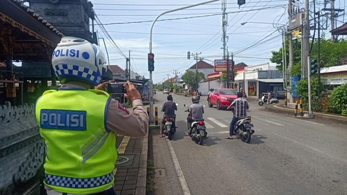 Petugas Satlantas Polres Jembrana saat memotret pelanggar lalu lintas di traffic light Pura Dalem Lelateng, Kecamatan Negara, Jembrana, Bali, Kamis (16/2/2023). (I Putu Adi Budiastrawan/detikBali)