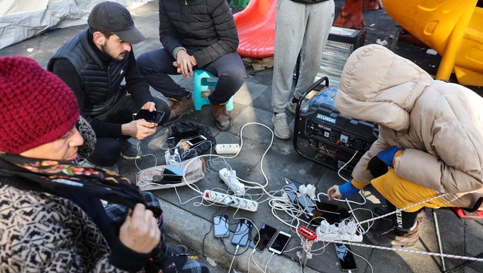 Potret Pilu Warga Turki Korban Gempa: Dingin, Kelaparan, Rumah Hancur People charge their phones as search for survivors continues, in the aftermath of a deadly earthquake in Hatay, Turkey, February 10, 2023. REUTERS/Umit Bektas