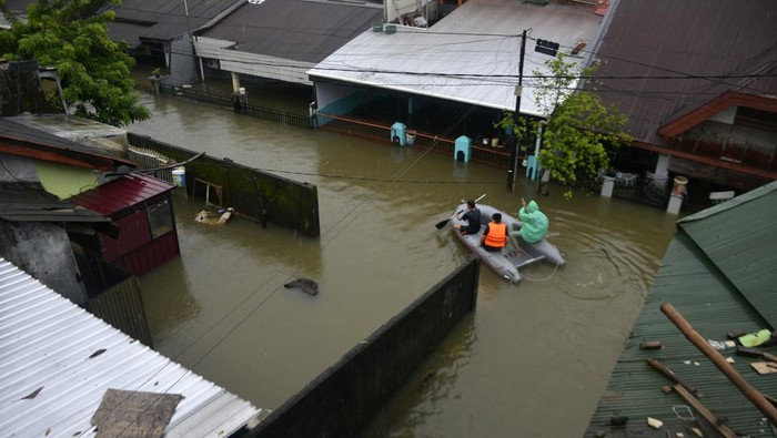 Warga melintasi jalan yang terendam banjir dengan perahu karet di Kecamatan Manggala, Makassar, Sulawesi Selatan, Kamis (16/2/2023).  Curah hujan yang tinggi dalam beberapa hari membuat sungai dan waduk di Kota Makassar meluap sehingga mengakibatkan sejumlah rumah terendam banjir dengan ketinggian mencapai 1,5 meter. ANTARA FOTO/Abriawan Abhe/rwa.