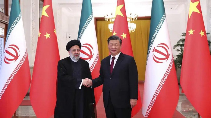 In this photo released by the official website of the office of the Iranian Presidency, President Ebrahim Raisi, left, shakes hands with his Chinese counterpart Xi Jinping in an official welcoming ceremony in Beijing, Tuesday, Feb. 14, 2023. (Iranian Presidency Office via AP)