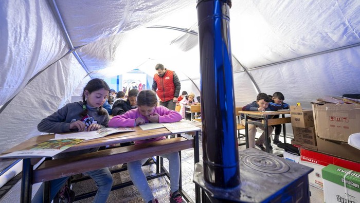 ADIYAMAN, TURKIYE - FEBRUARY 16: Earthquake victim children are seen at a makeshift tent class after voluntary teachers established came together and set up three tents at the Sumerevler Athletic Track, where the tent city is located, in Adiyaman, Turkiye on February 16, 2023. The voluntary teachers, who divided the tents into primary, secondary and high school groups, started their education by hanging the Turkish flags on their doors. On Feb. 06, a strong 7.7 earthquake, centered in the Pazarcik district, jolted Kahramanmaras and strongly shook several provinces, including Gaziantep, Sanliurfa, Diyarbakir, Adana, Adiyaman, Malatya, Osmaniye, Hatay, and Kilis. Later, at 13.24 p.m. (1024GMT), a 7.6 magnitude quake centered in Kahramanmaras' Elbistan district struck the region. (Photo by Aytac Unal/Anadolu Agency via Getty Images)